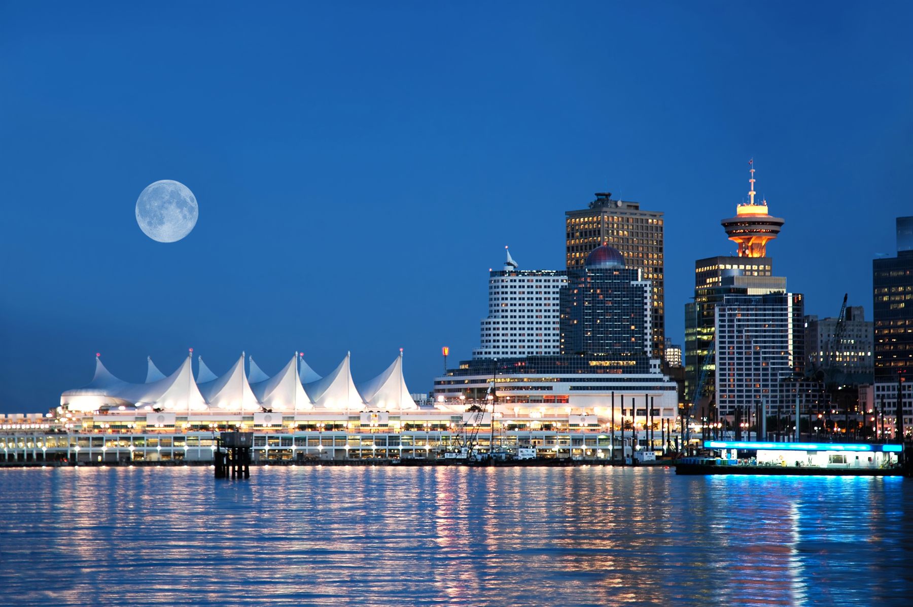 Canada Place cruise terminal and the Vancouver skyline at night under a full moon