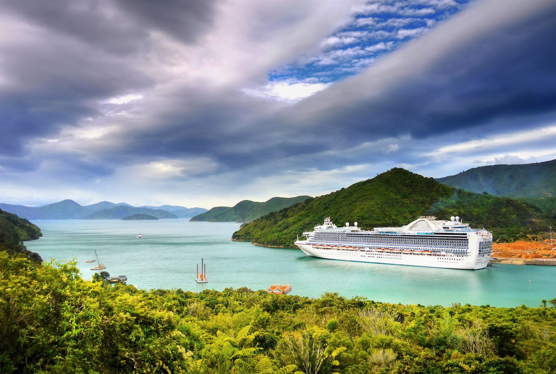 A large cruise ship sailing along a scenic coastline